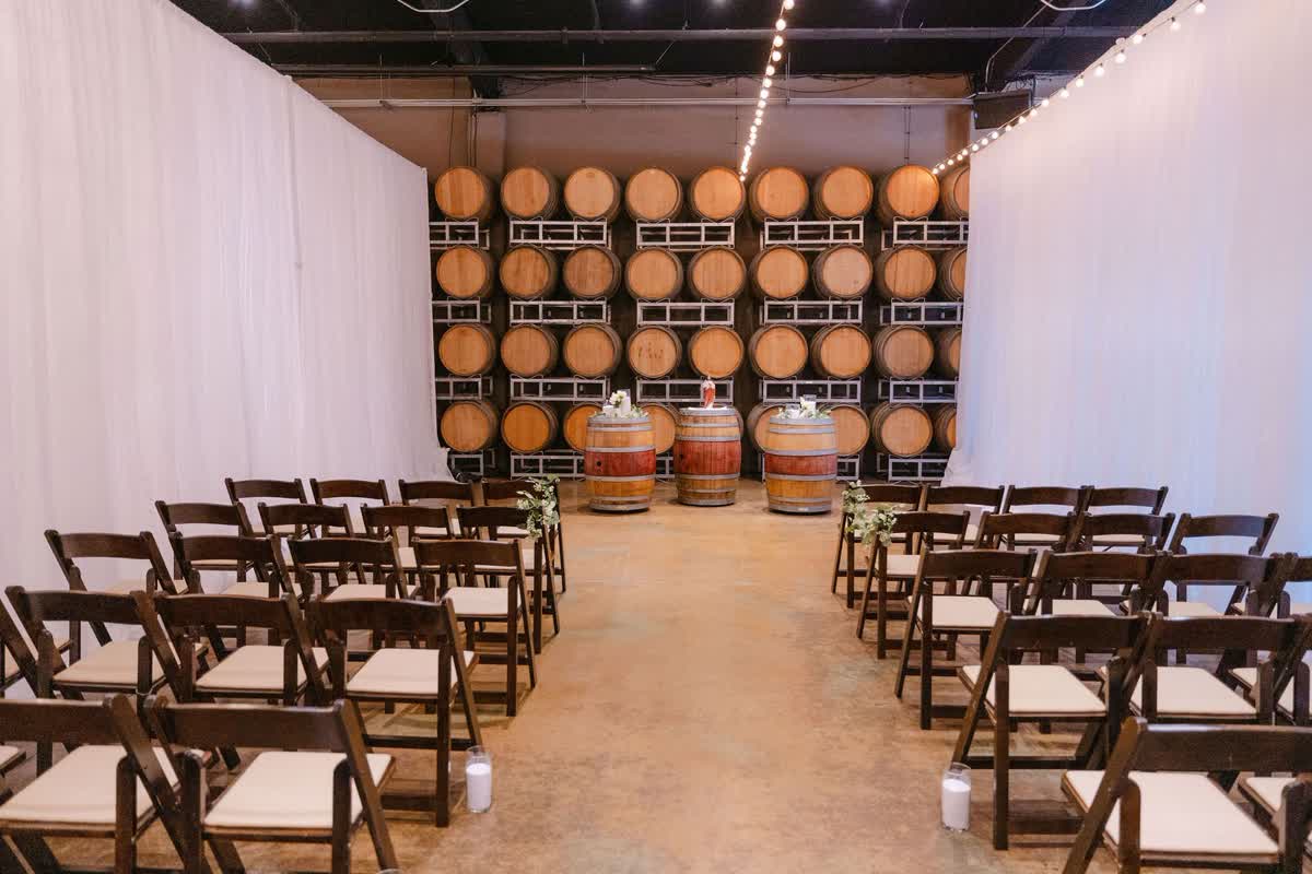 Indoor ceremony chairs arranged in a winery barrel room
