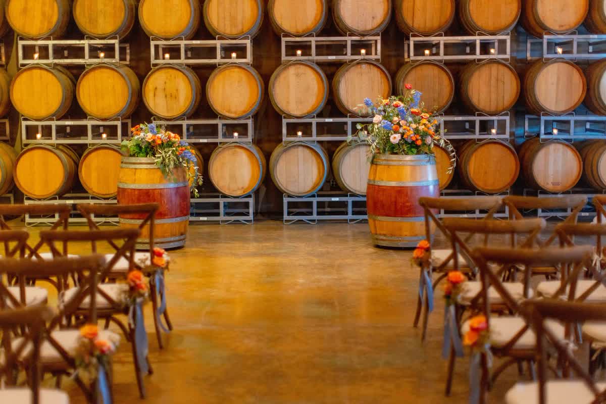 Wedding ceremony seating arranged in a winery barrel room